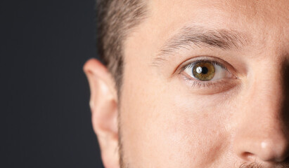 Fototapeta premium Man with beautiful eyes on black background, closeup. Space for text