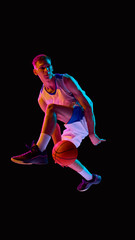 Basketball player creative airborne move in neon light with focused face. Concept of advertising, motivational design, youth culture, sports branding, and emotional inspiration.