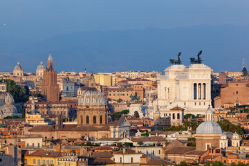 Fototapeta premium Panoramic view of Rome's historic cityscape under a clear blue sky at sunset