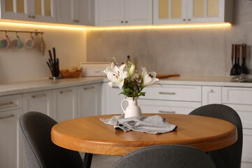 Dining table, chairs and floral decor in kitchen. Interior design