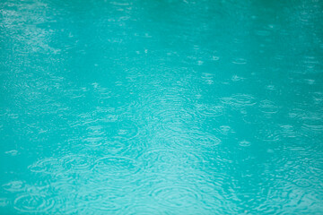 A body of water with raindrops falling on it