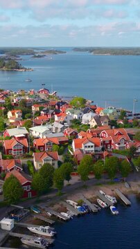 vertical aerial video of Swedish nature, drone view of Sandhamn island in Stockholm archipelago, traditional colourful houses on an island in the Baltic Sea in Sweden, Scandinavian nature