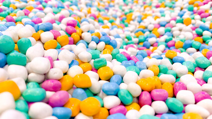 Close up colorful decorative stones, small shiny pebbles in bright pastel colors, background texture for design and decoration.
