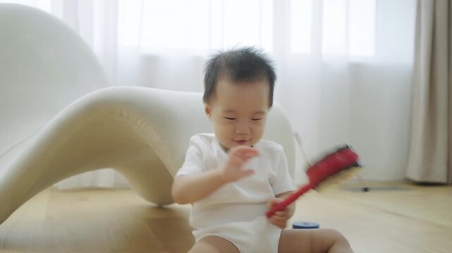 Baby playing with a rattle on the floor and then starts crawling