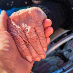 Elderly Hand And Younger Hand In Tender Connection: Symbol Of Care, Support, Generations And Human Touch