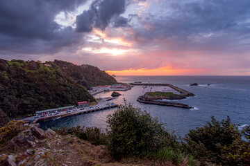 Dramatic Sunset Over Cudillero Fishing Port and Harbor, Asturias, Spain: Panoramic View of Atlantic Coastline and Verdant Hillside Scenery at Twilight
