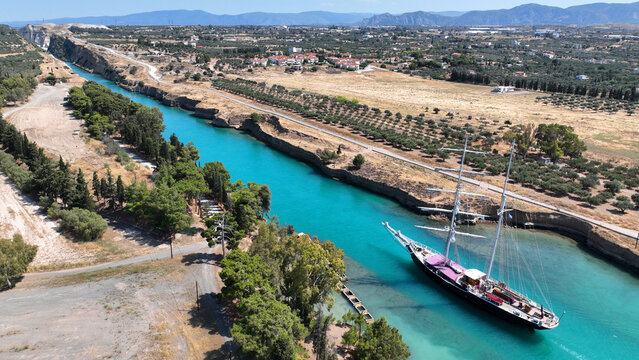Aerial drone photo of classic sailing boat crossing narrow Corinth canal of Isthmus from West submersible bridge and narrow opening of Corinthian gulf to Saronic gulf, Loutraki, Greece