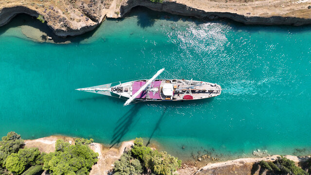Aerial drone photo of classic sailing boat crossing narrow Corinth canal of Isthmus from West submersible bridge and narrow opening of Corinthian gulf to Saronic gulf, Loutraki, Greece