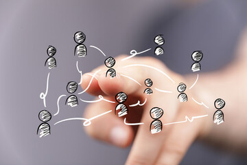A human hand interacts with a virtual network of people icons, symbolizing global social...