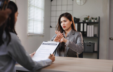 Businesswoman refusing to sign contract agreement in office meeting