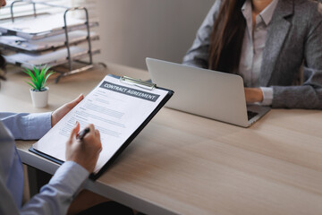 Businesswomen reading and signing contract agreement