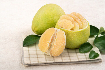 Fresh pomelo fruit with leaf on white table background.