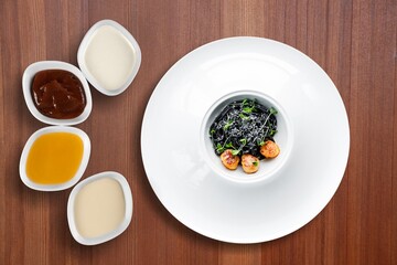 Black tasty pasta dish with vegetables in bowl