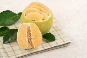 Fresh pomelo fruit with leaf on white table background.