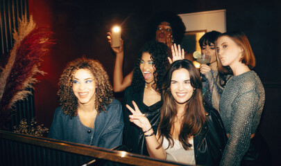 Group of friends having fun and posing together in a nightclub bathroom