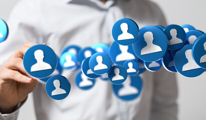 A businessman interacts with a network of digital profile icons, symbolizing social connections and networking.