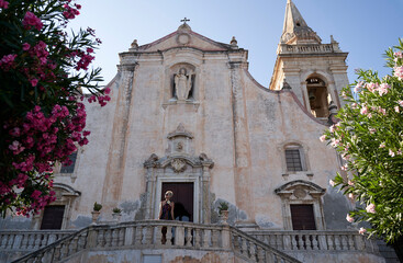 pretty fashion lady standing on terrace before Cathedral in Piazza IX Aprile, Taormina, Sicily