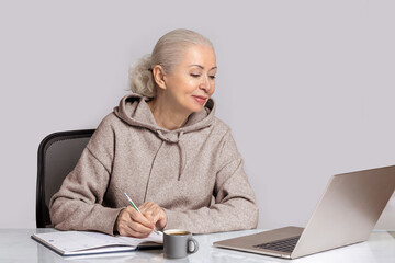 Senior woman analyzing finances on laptop in home office