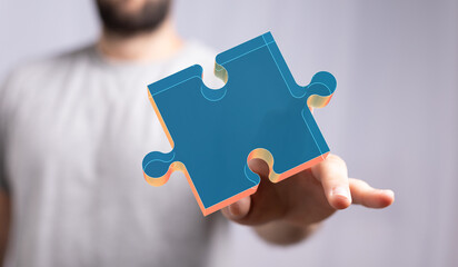 Hand holding a digital puzzle piece.  Concept of solution, connection, and teamwork.