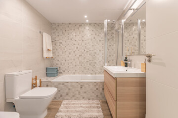 Modern bathroom design with a matte black floating cabinet, a large circular mirror, and indirect ceiling lighting