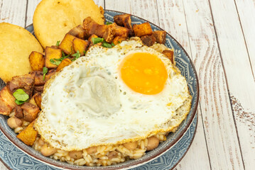 Wheat cuchuco with pork backbone, fava beans, and peas, thick and steaming in a baked clay bowl