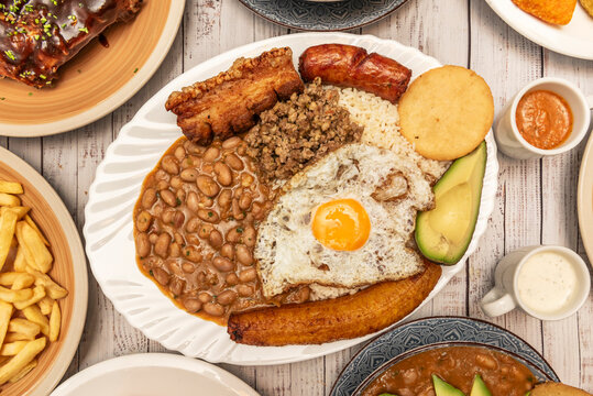 Arroz atollado (rice atolla) with chicken, pork, and seafood, mixed with vegetables and seasonings, served in a shiny metal cauldron