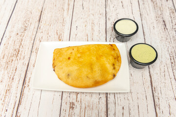 Chicken and avocado empanadas with blue corn masa, accompanied by spicy mango salsa and pickled red onion