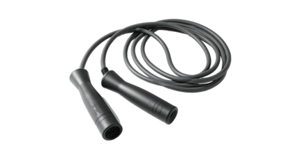 Black jump rope lies coiled against a black background, handles and cord visible