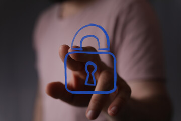 Digital security and privacy concept with a human hand touching a virtual padlock symbol. Ideal for technology, data safety, and network protect