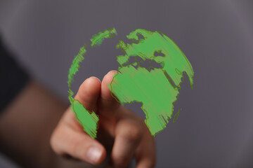 A human hand interacts with a vibrant green digital globe, symbolizing global environmental awareness, sustainability, and technological connect