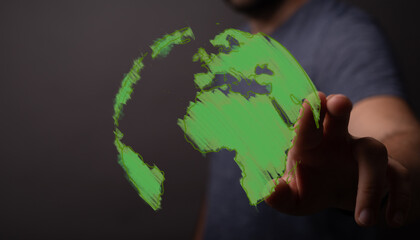 Digital visualization of a hand touching a luminous green world map, highlighting themes of environmental responsibility, global connectivity, a