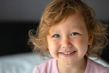 Portrait of smiling blond girl with blue eyes showing happiness