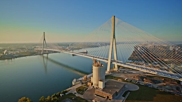 Aerial drone flyover of a freighter moving beneath the massive Gordie Howe International Bridge.