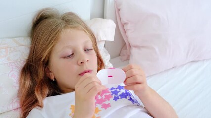 The child in the bed has a minimalistic interior. A girl with duct tape on her lips for breathing through her nose. Taking care of a student's sleep. Therapy of snoring in children. Somnology.