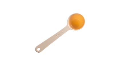 A measuring spoon is filled with amber liquid, placed diagonally against a black background