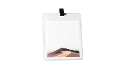 A rectangular badge with a landscape picture, attached to a clip, set against black