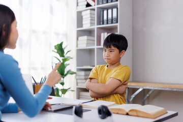 Asian teacher scolding a stubborn student at school desk