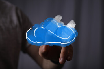 Person's hand interacts with a vibrant blue cloud icon, symbolizing modern cloud computing, secure data storage, and digital network services.