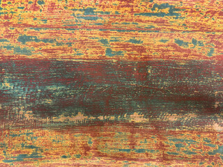 Close up of weathered and decayed solid wood texture with colorful vibrant paint color, brown, yellow, blue, and red. Seamless timber solid wood background texture