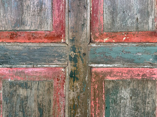Close up of colorful vibrant rustic wood door panel with carving and red frame. In rustic brown wood, and corroded rusty colors and red paint. Old vintage, traditional, and retro feel. Seamless