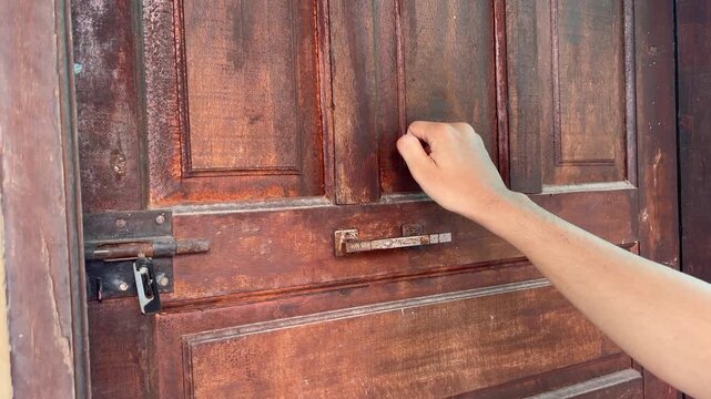 Hand knocking on the door.