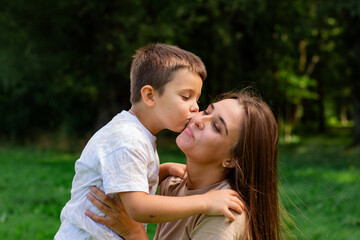 Fototapeta premium Close up of mother and son exchanging loving whispers and giggles. Perfect illustration of secure attachment and childhood happiness.