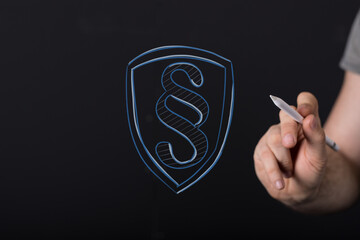 Abstract concept of digital law, legal protection, and cybersecurity, featuring a paragraph symbol within a shield, interacted with by a hand. I