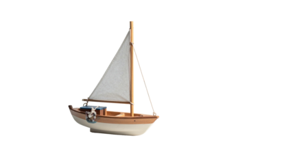 Wooden toy sailboat with a white sail against a solid black background