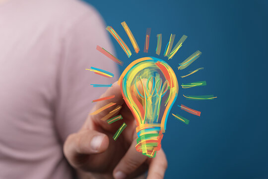 Hand holding a vibrant lightbulb,innovation, creativity, solution, inspiration, idea, technology, progress, success, future, bright, colo