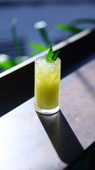 Passion fruit juice in a glass on a table in a cafe in the morning sun