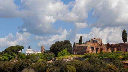 View of Rome historical center with Capitoline bell tower, Altar of Nation and Palatine Hill ancient ruins with beautiful clouds above