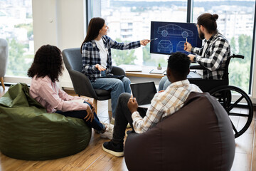 Group of diverse individuals discussing car design concepts with blueprint on monitor. Collaboration