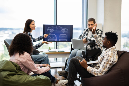Diverse group of adult professionals collaborating on car prototype design project in office. Includes male and female engineers and designers using laptop, screen, and discussion. - Powered by Adobe