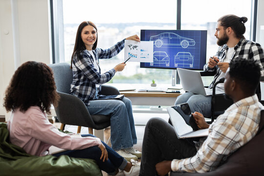 Team of diverse engineers and designers collaborate on futuristic car design project using digital displays and charts promoting innovation and teamwork - Powered by Adobe